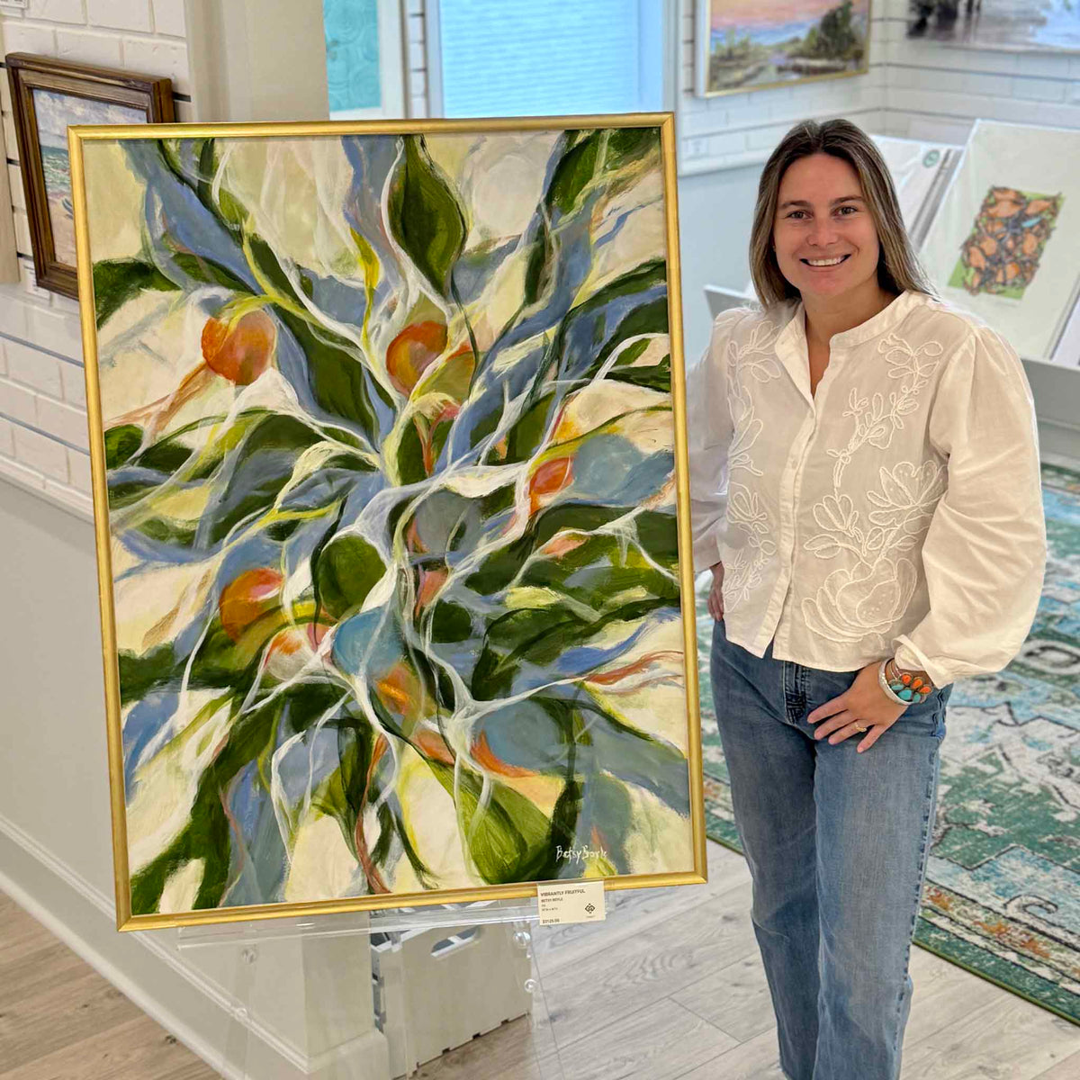 Large-scale Vibrantly Fruitful original oil painting by South Carolina artist Betsy Boyle displayed at Gray Man Gallery in Pawleys Island, featuring abstract botanical foliage and fruit in blue, green, cream, orange and coral with a slim gold frame
